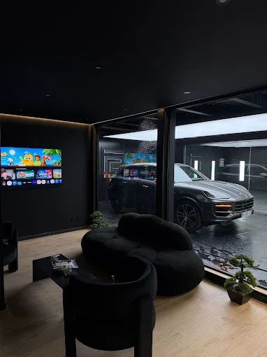 Intérieur de l'atelier Reyce, avec une Porsche derrière la vitre
